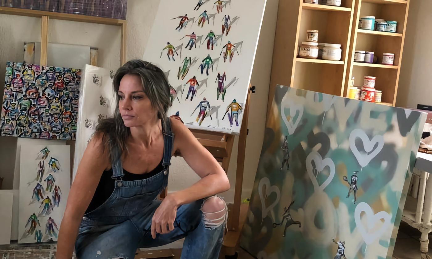 Heather Blanton sitting with a few of her art pieces