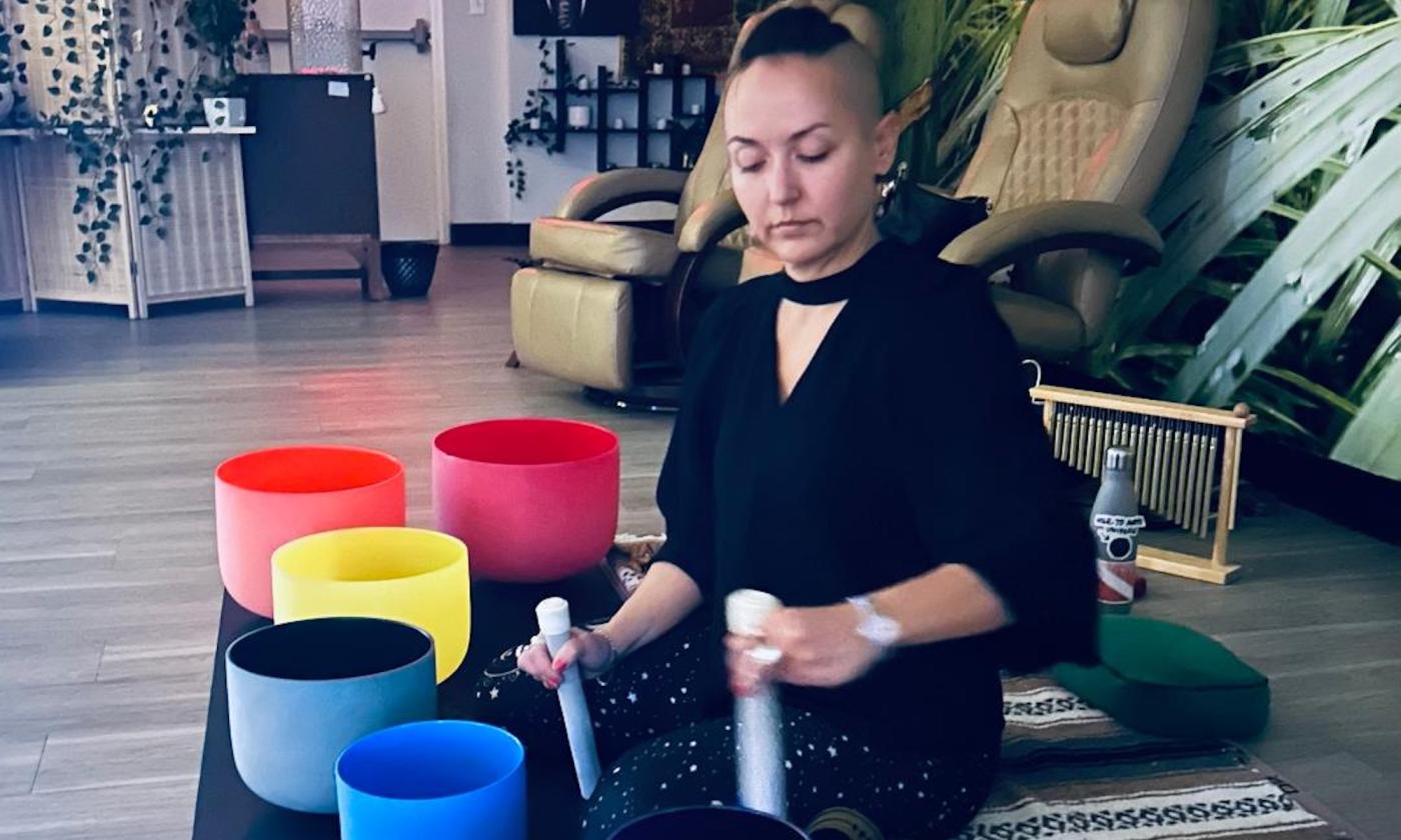 A yoga teacher plays the sound bowls