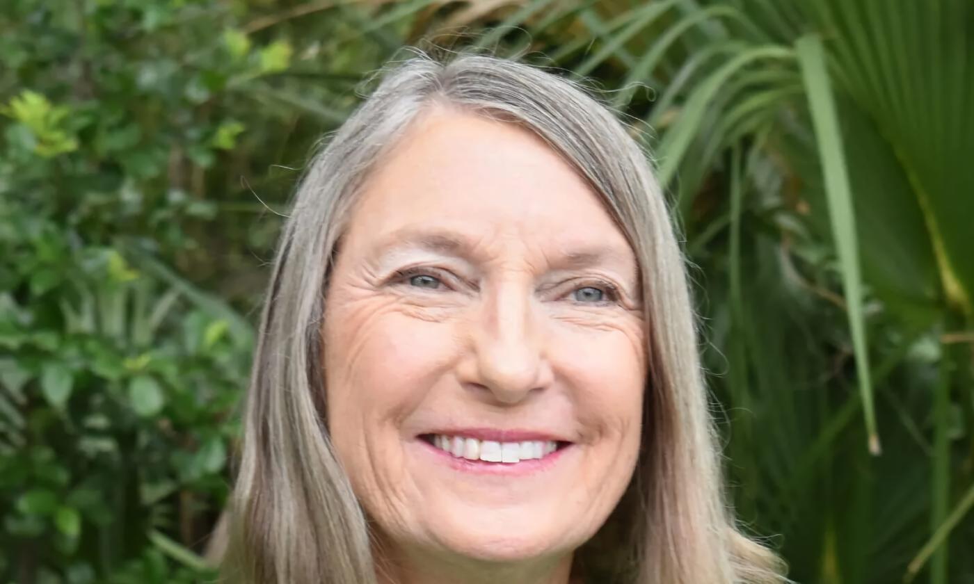 Elizabeth Randall, author, outside in front of palms