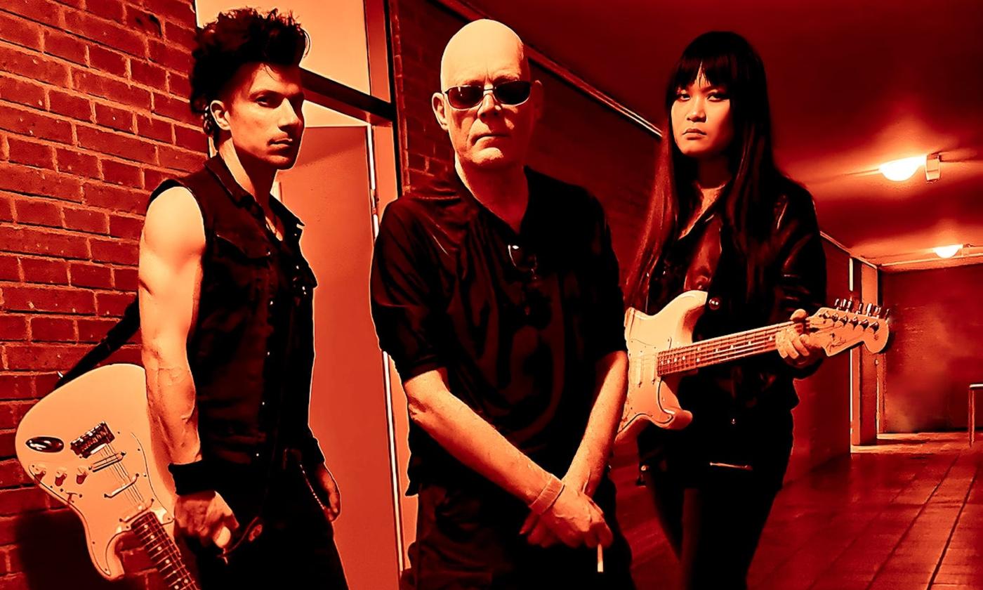 Bandmates from The Sisters of Mercy pose with their guitars.