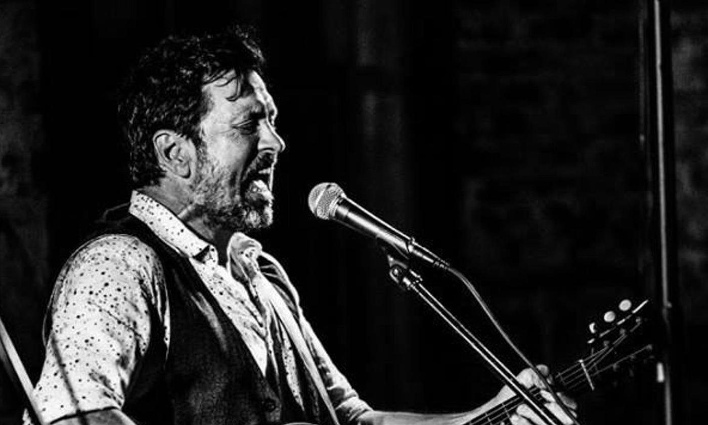 Will Kimbrough performing live, playing an acoustic guitar