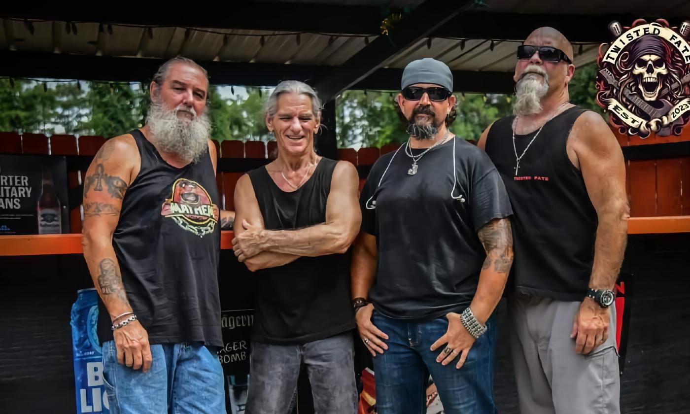 Four members of Twisted Fate from NE Florida, standing in front of an outdoor bar