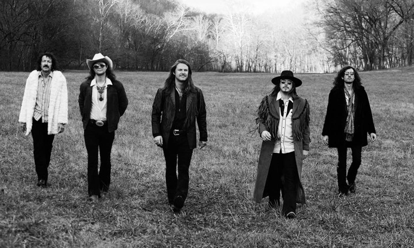 The band Hippies & Cowboys walking across a pasture