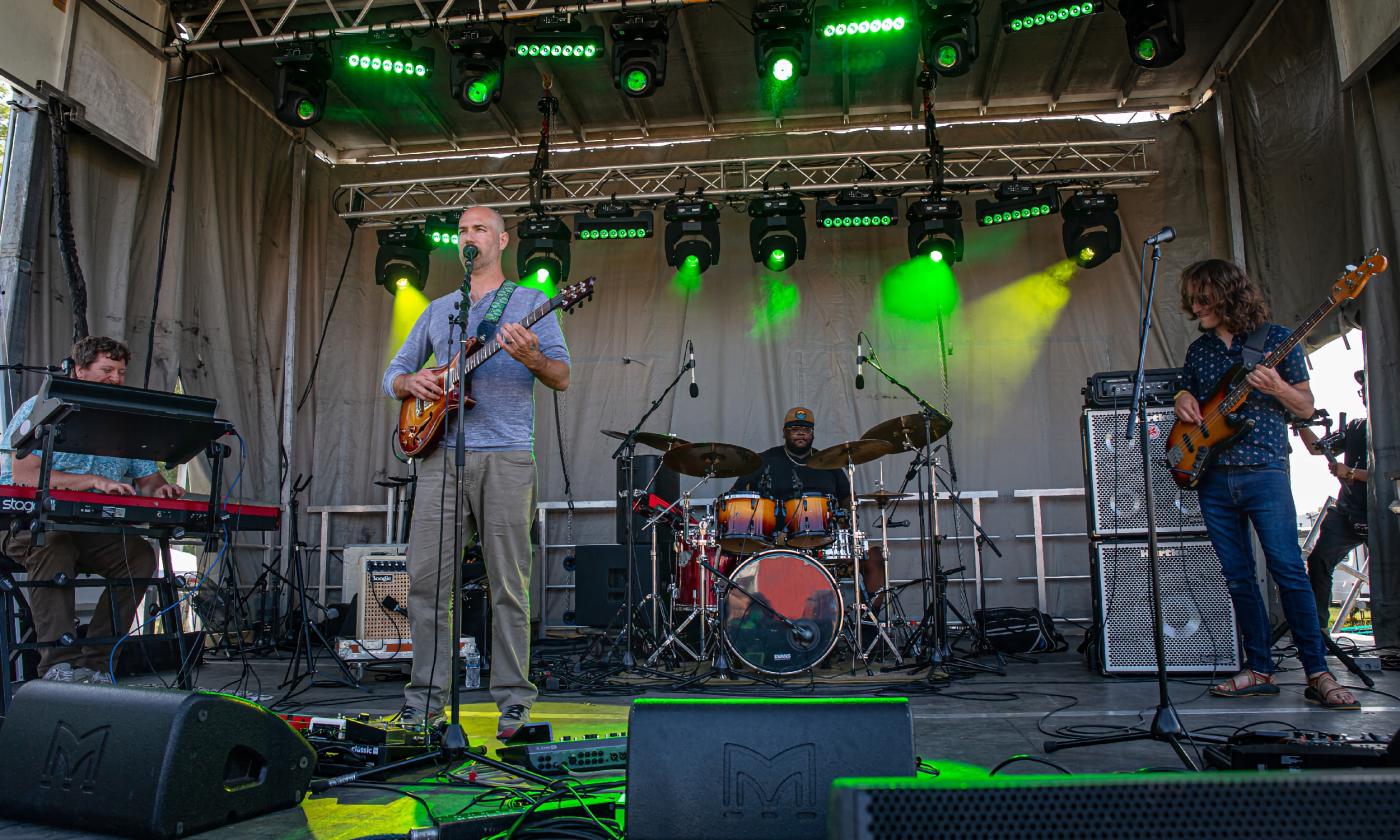 The four-piece band bodhicitta on a stage with green lights in the back