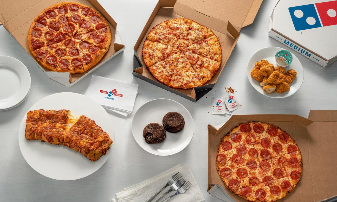Pizza, side snacks, and dessert presented
