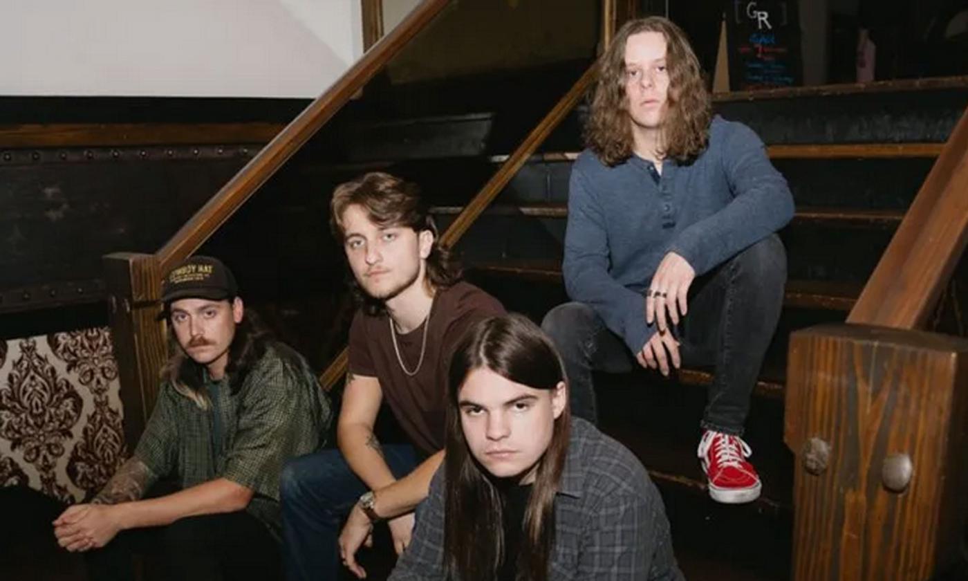 Four members of the alt-rock band Lightwatch sitting on stairs