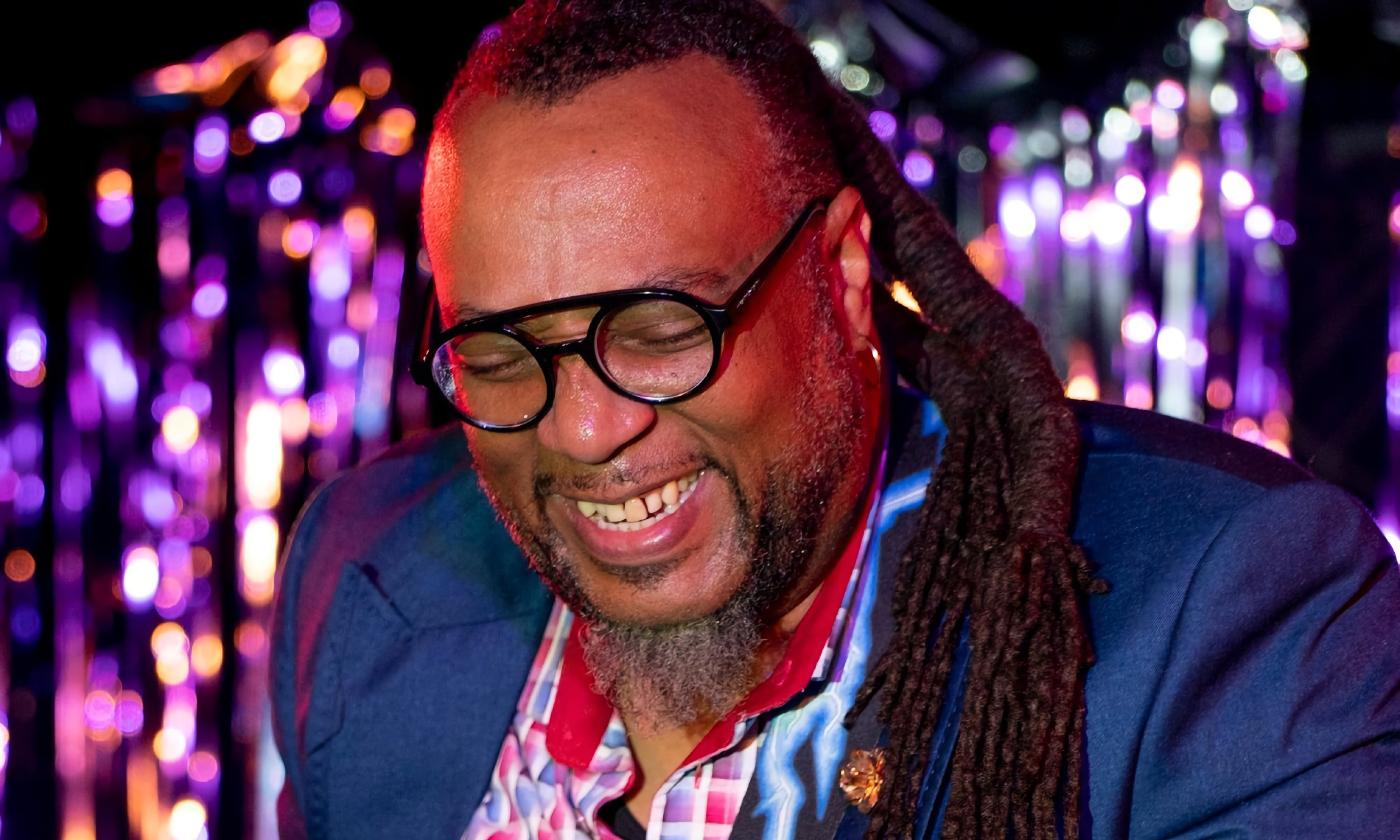 Eric Carter, blues musician on stage with purple lights in the background