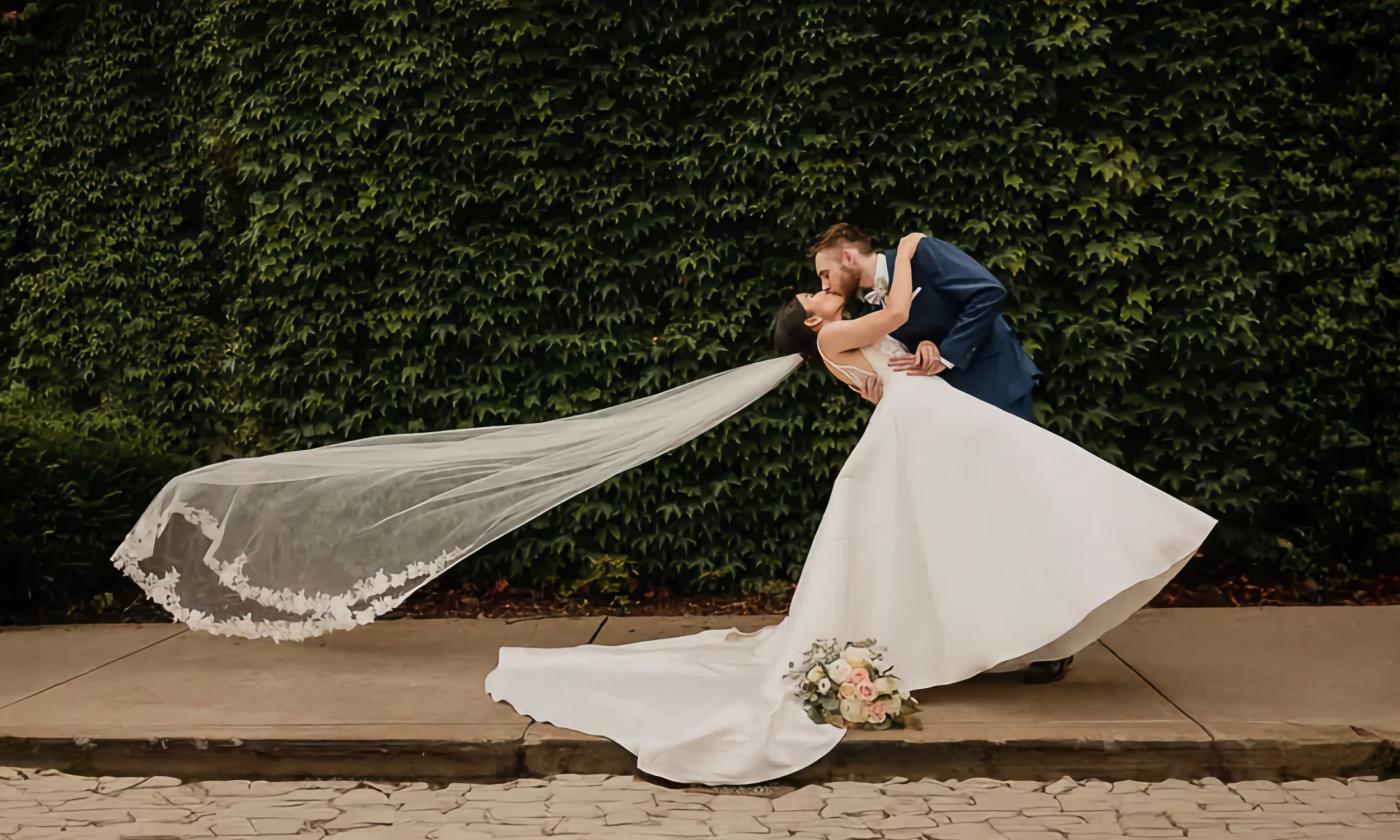 A bride and groom giving each other a quick kiss