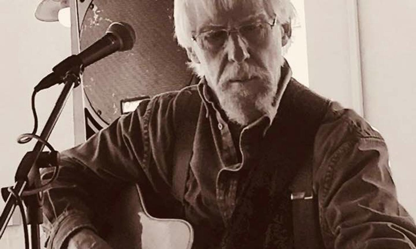 Songwriter Bob Patterson tuning his twelve-string guitar