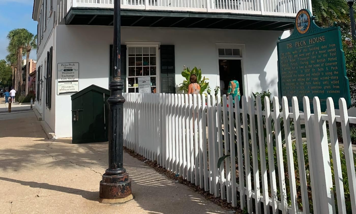 The entrance to the Peña-Peck house is a gate through a picket fence