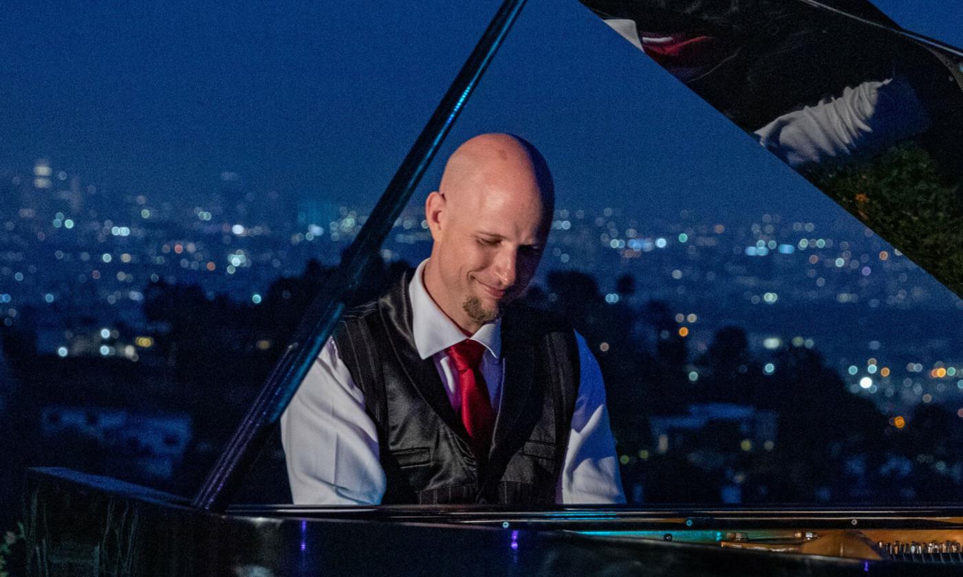 Pianist Jeremy Weinglass as piano, with city night skyline in background