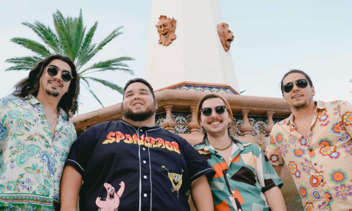 The band Dionysus standing outside under a palm tree