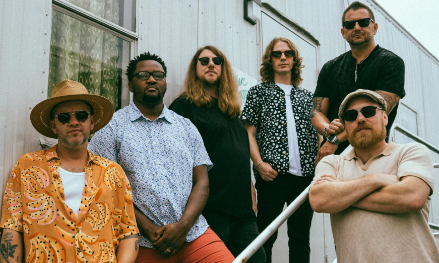 Marc Broussard, wearing glasses, is pictured alongside others on a staircase.