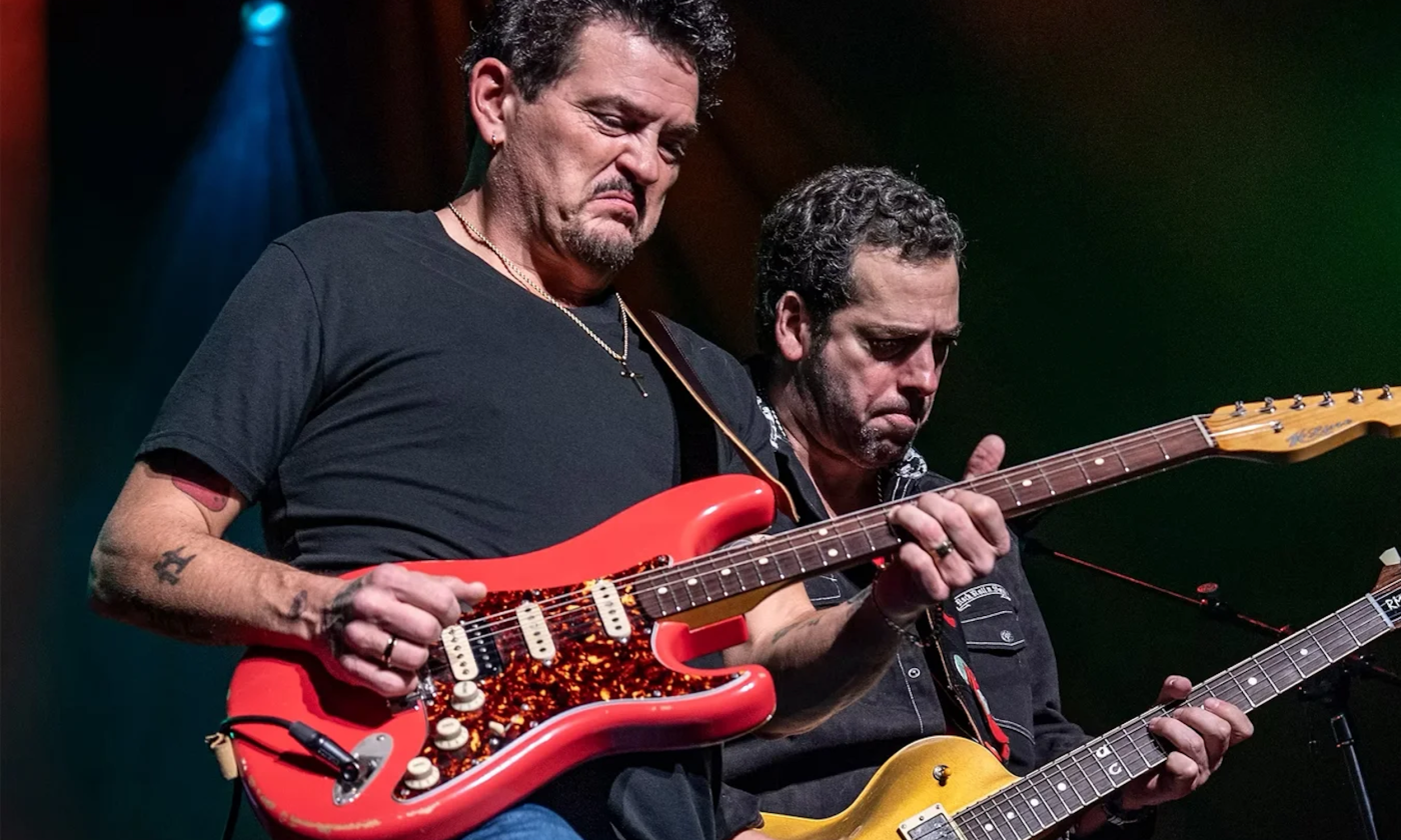 Mike Zito and Albert Castiglia wear black shirts and perform on stage.