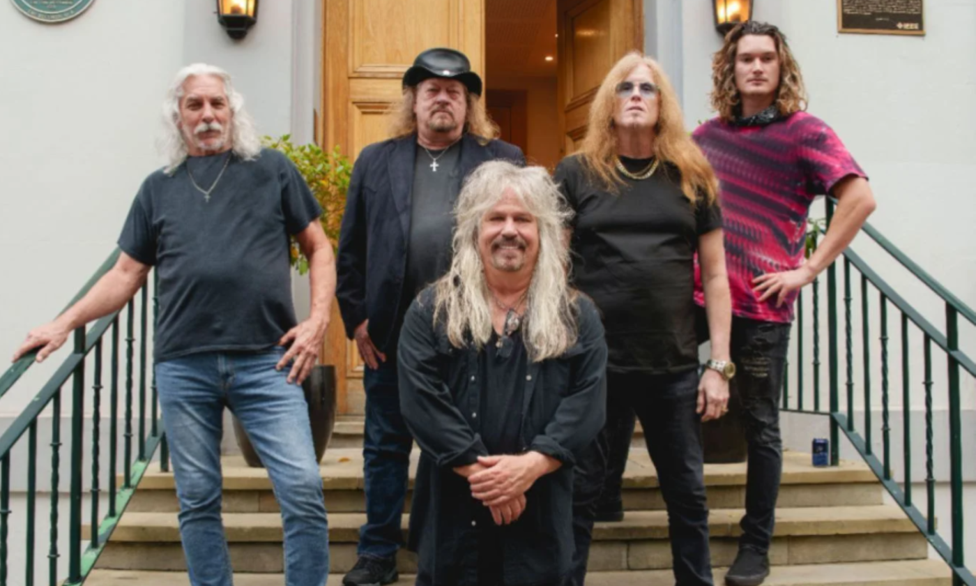 Bandmates from Molly Hatchet wear dark clothing and pose on a staircase.