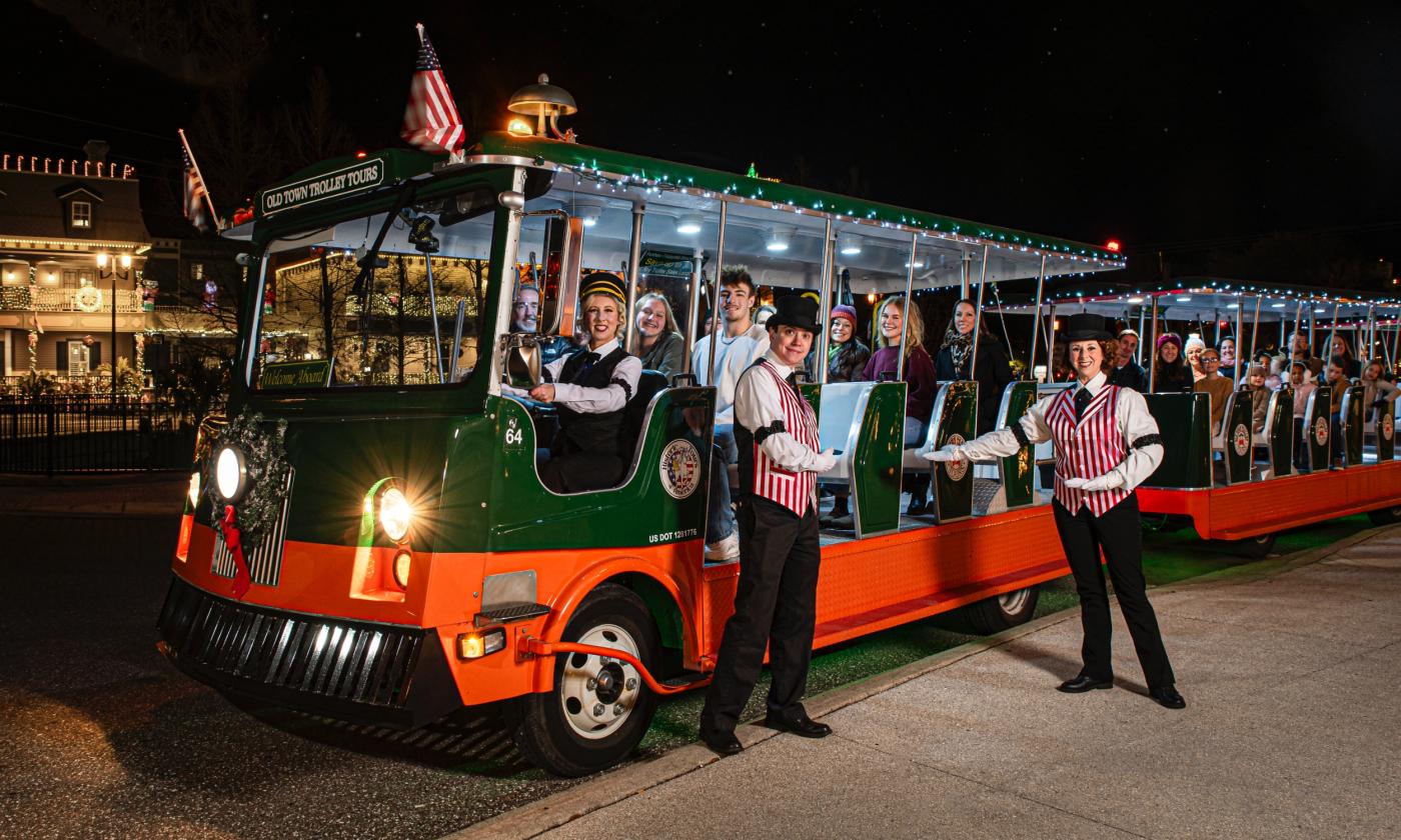 An Old Town Trolley loaded with passengers embarking on a Nights of Lights Tour