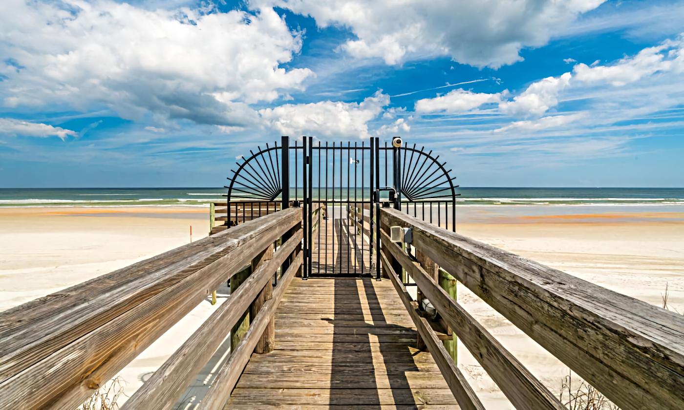 The private gate to the beach on a boardwalk from a condo community