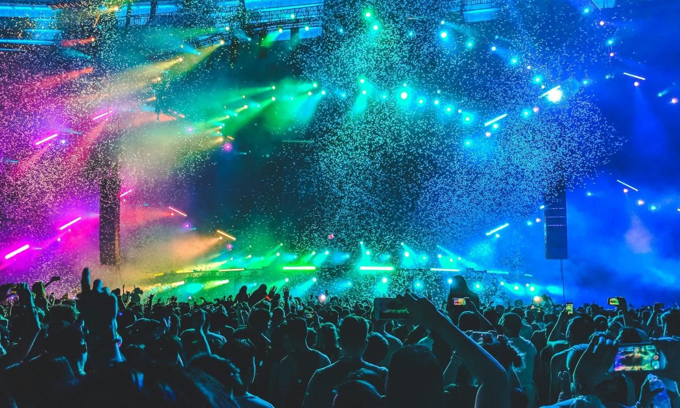 Vibrant lights illuminate the stage of a high-energy concert.