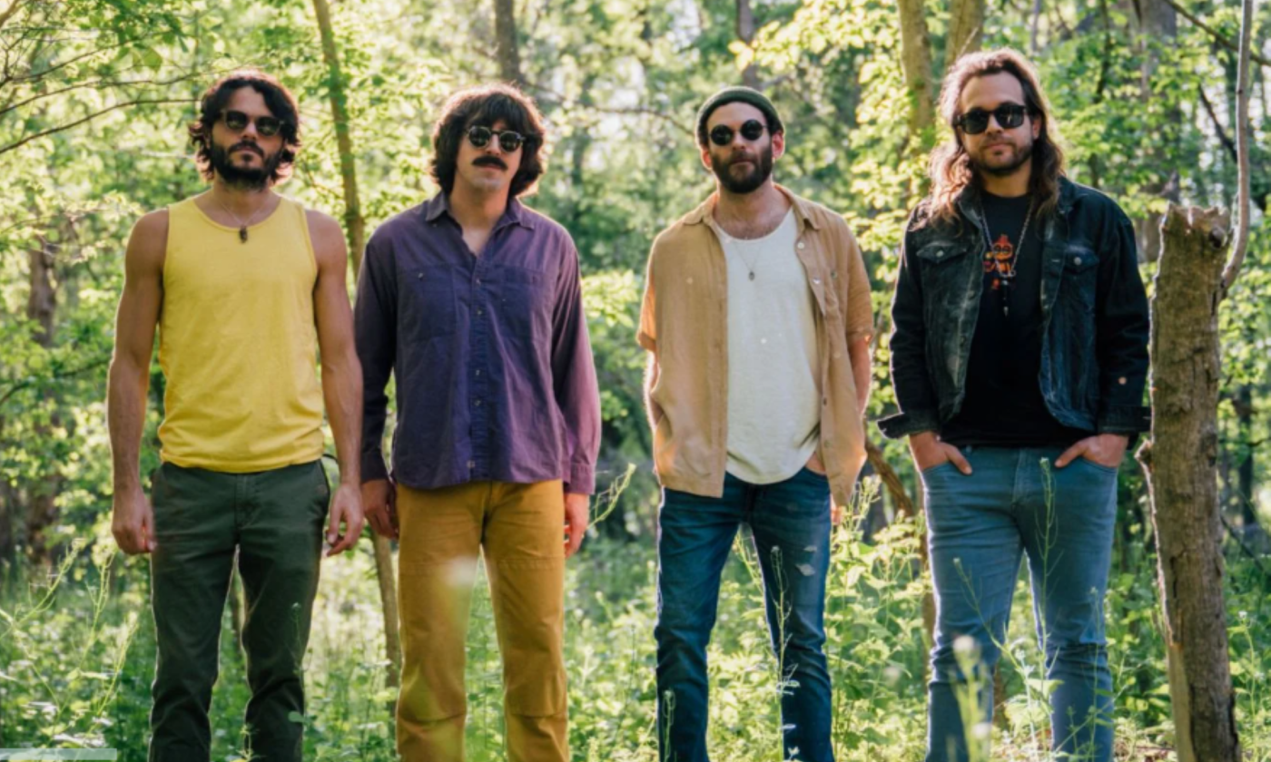 Bandmates from Goose smile and pose in black glasses.