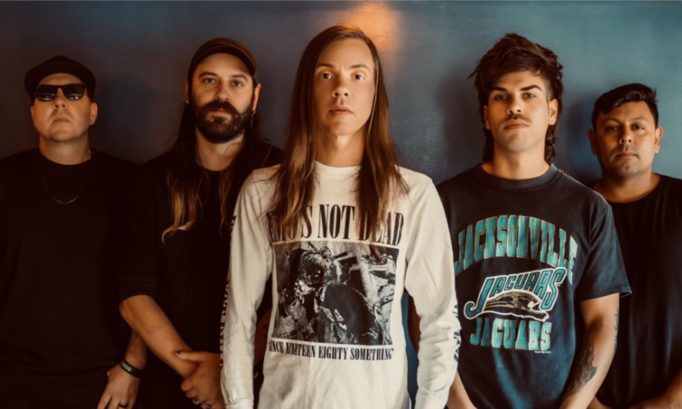 Bandmates from The Red Jumpsuit Apparatus pose in front of a grey backdrop.