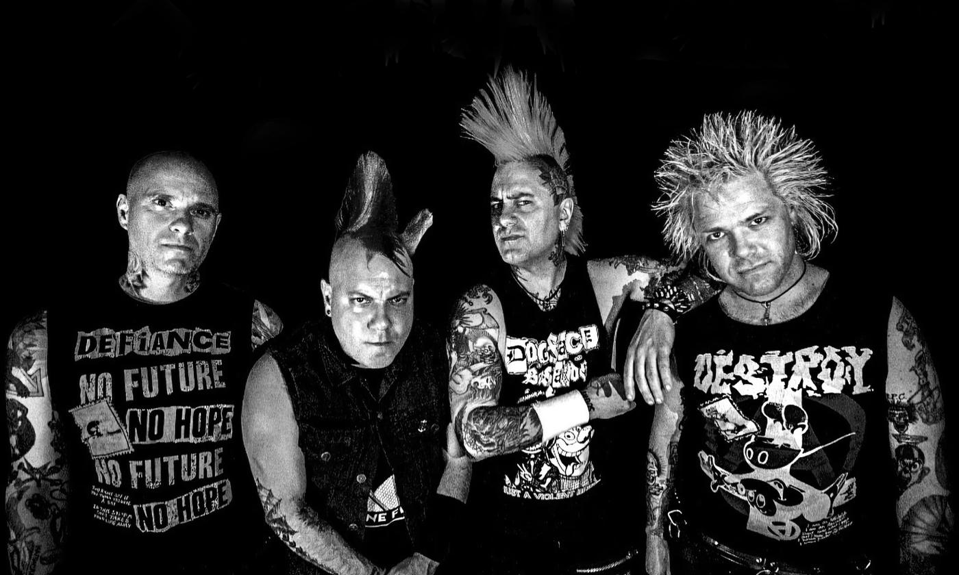 Four members of the punk rock band Casualties in front of a black background