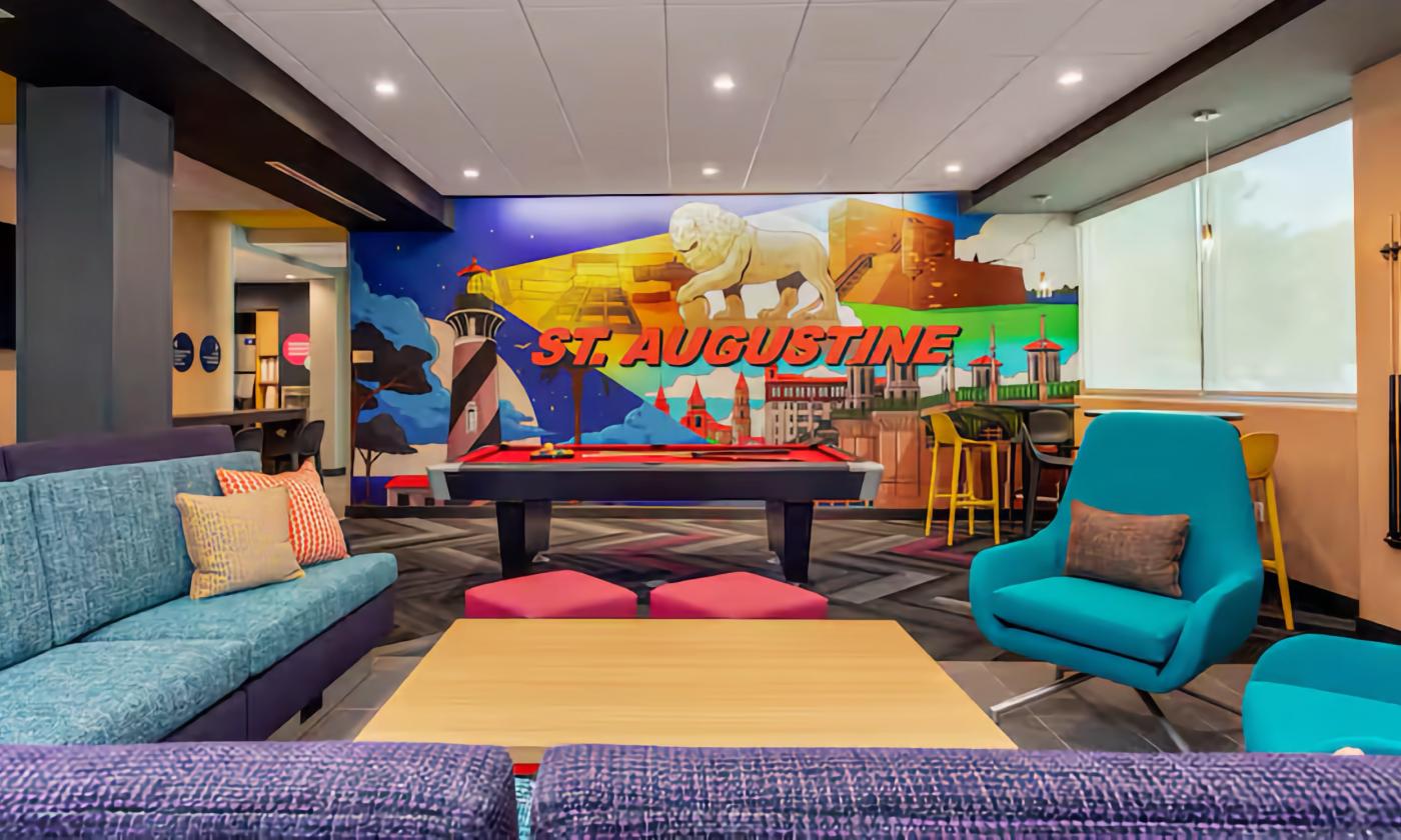 The lobby and game area with a St. Augustine mural in the back