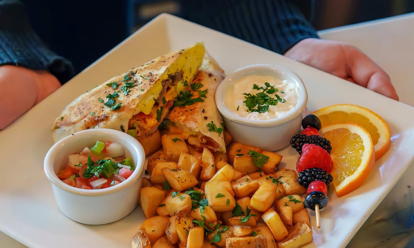 A breakfast burrito, salsa, and fried potatoes offered at Voco hotel on Anastasia Island