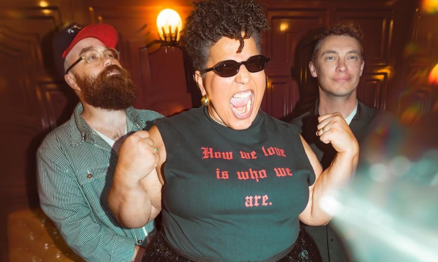 Members of Alabama Shakes stand together beneath warm, ambient lighting.