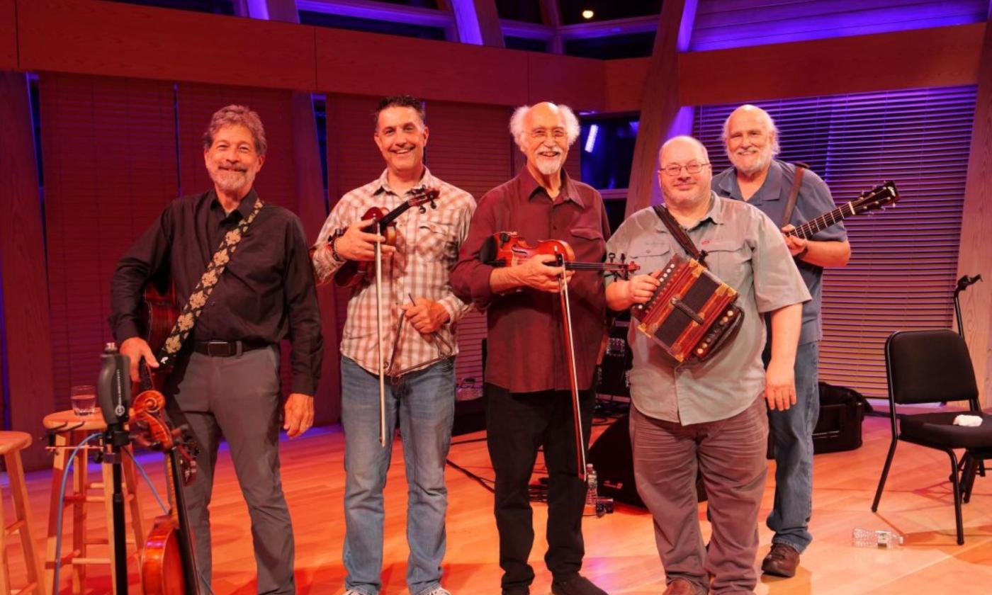 Bandmates from BeauSoleil Avec Michael Ducet smile and pose with their musical instruments.