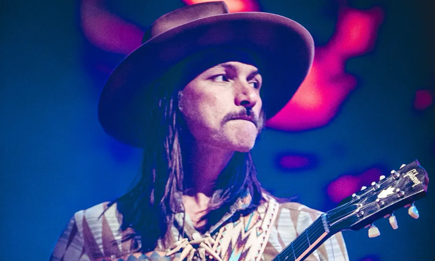 Duane Betts clutches his guitar and performs on stage.
