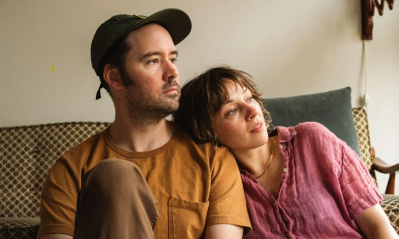 Bandmates from Watchhouse pose while sitting on a couch.
