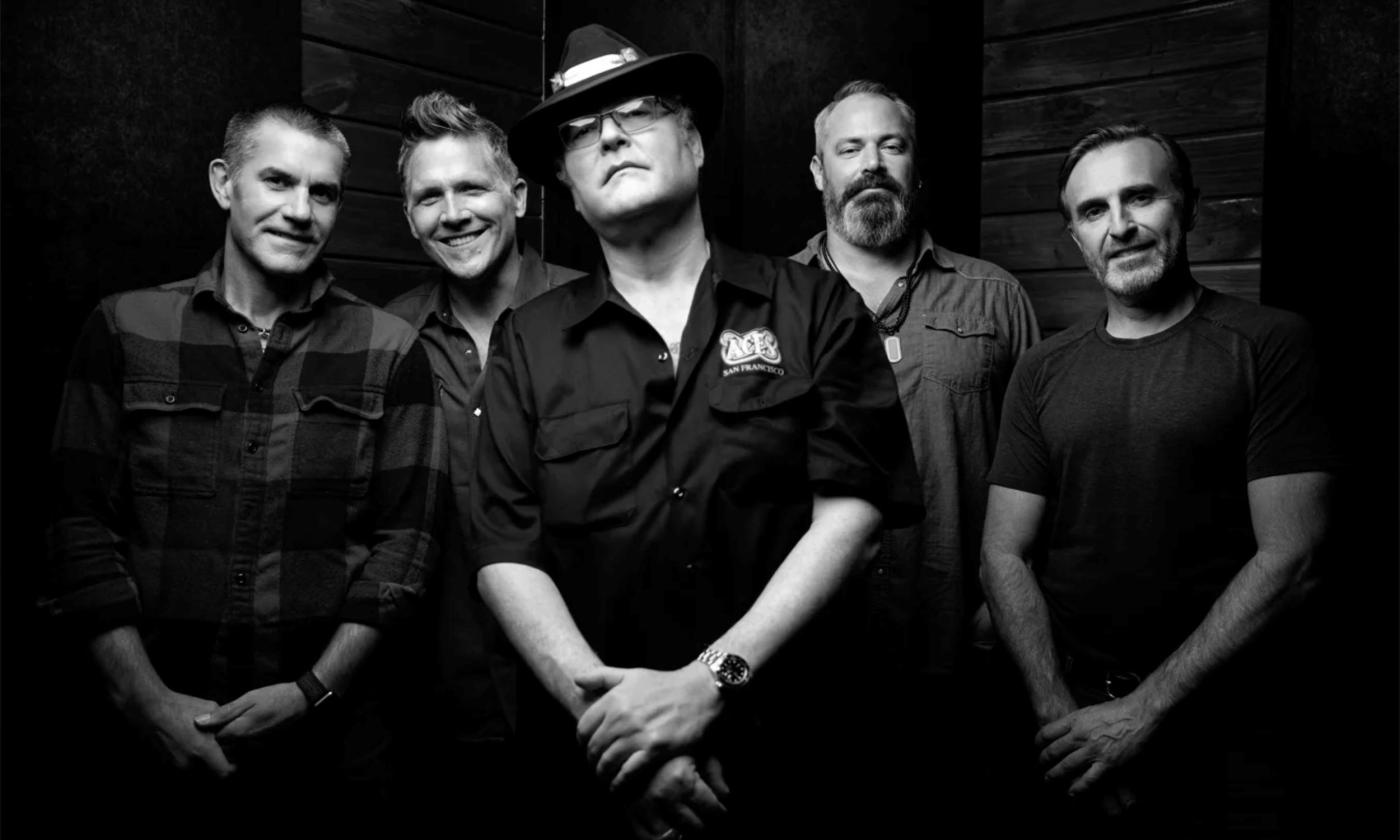 Bandmates from Blues Traveler pose in a black and white photograph.
