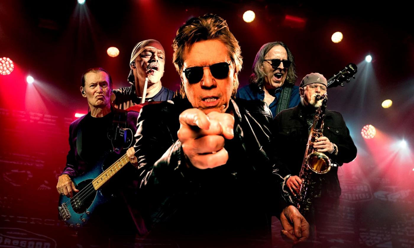 George Thorogood and The Destroyers pose and perform on stage.