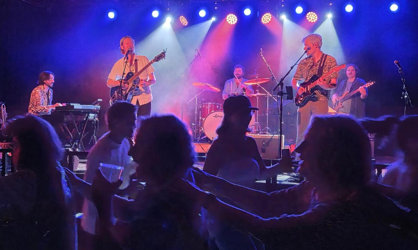 The band Jammy Buffet on stage with a standing and dancing crowd in front
