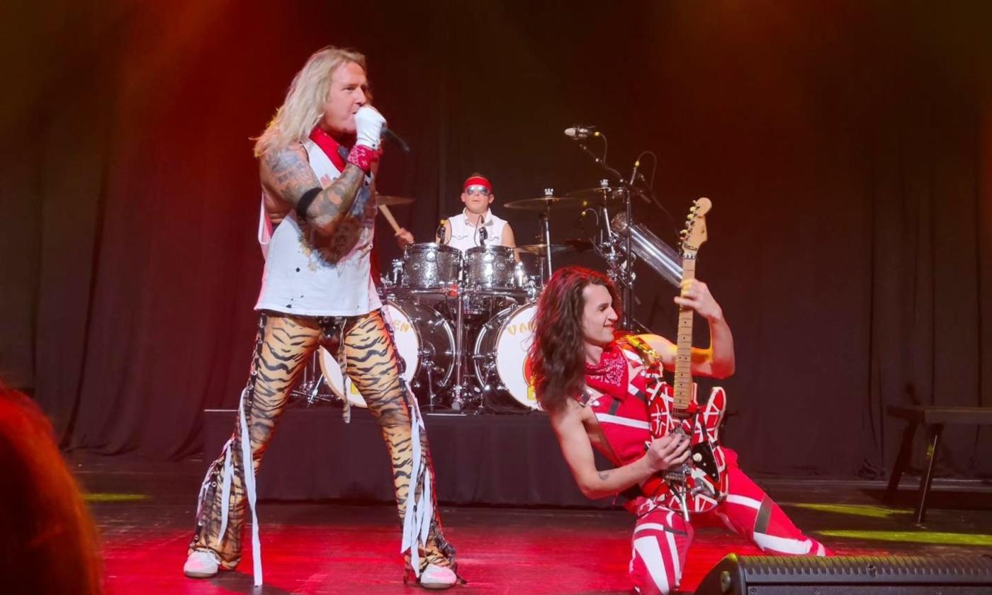 Bandmates from the Van Halen Tribute Band perform on stage.