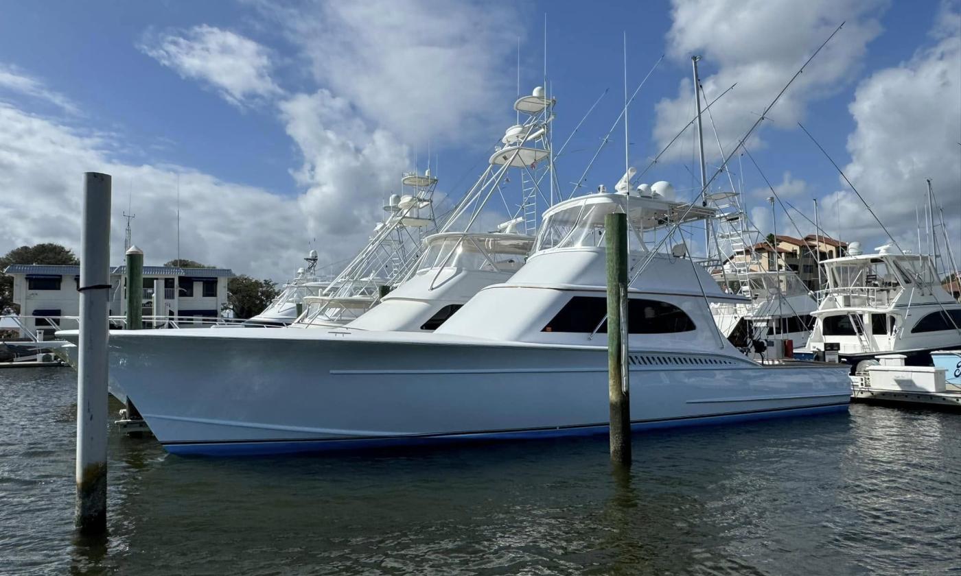 Boats at a marina under a blue sky with scattered white clouds