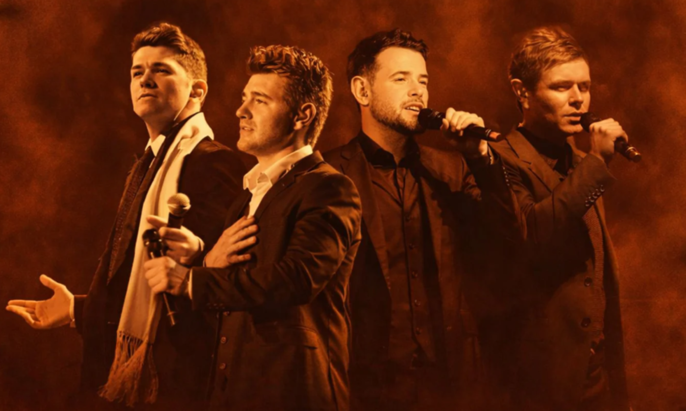 Bandmates from Celtic Thunder sing in front of a brown backdrop.