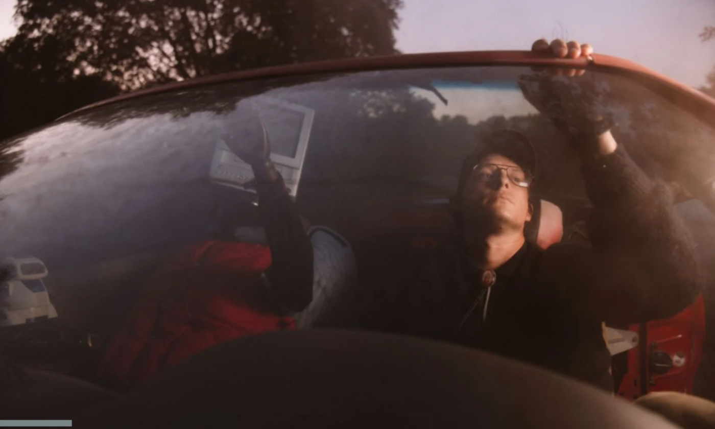 Stephen Wilson Jr. wears glasses and poses in his car.