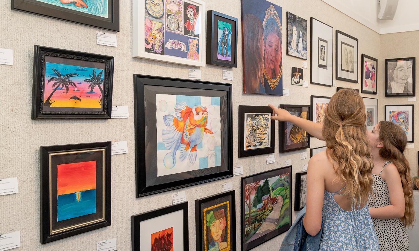 Girls pointing at displayed art