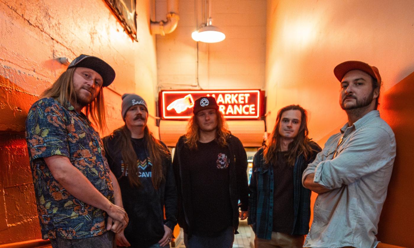 The band Kash'd Out standing in a hallway with orange walls