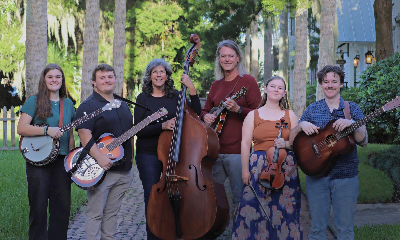 The six-members of the band, North Florida Taildraggers, standing outside with their instruments