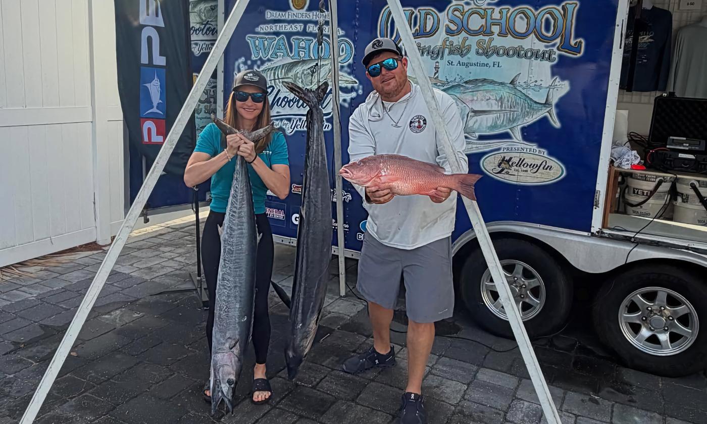 A man and a woman with three fish they caught during the Wahoo Shootout