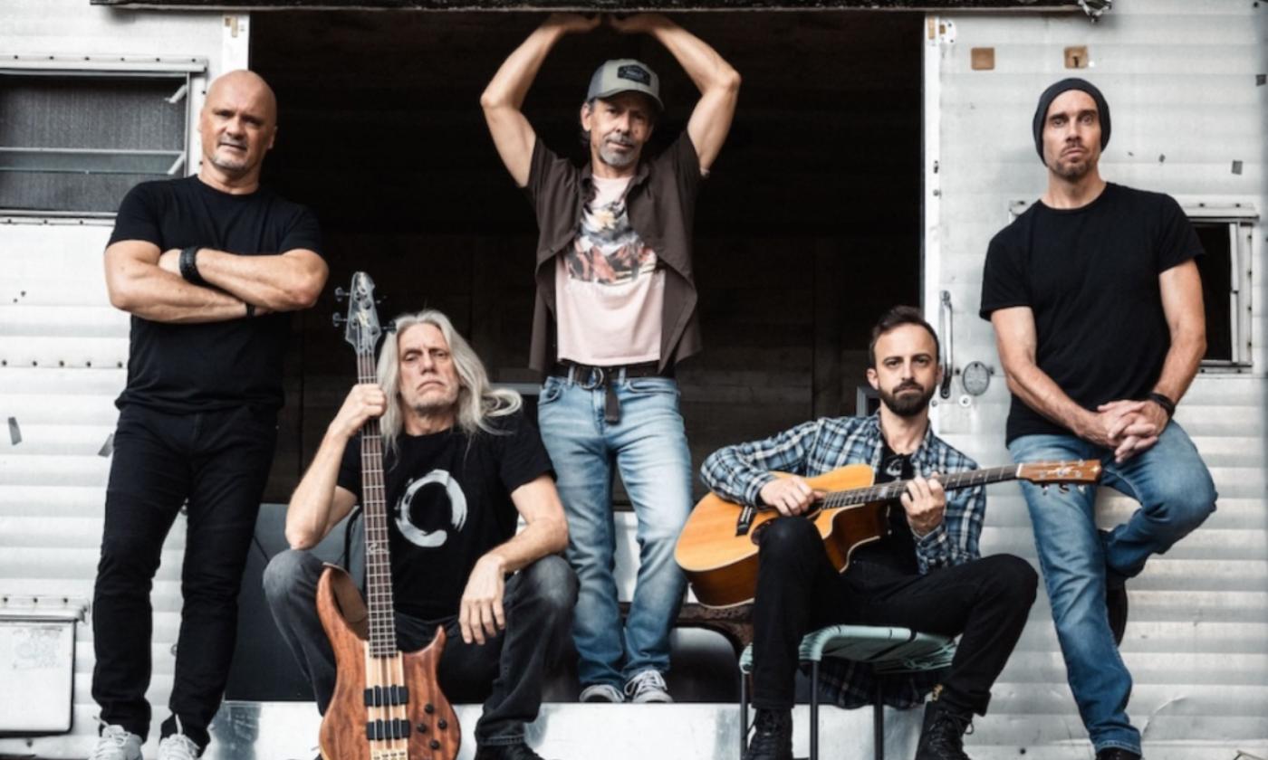 Bandmates from Given to Fly pose with their musical instruments.