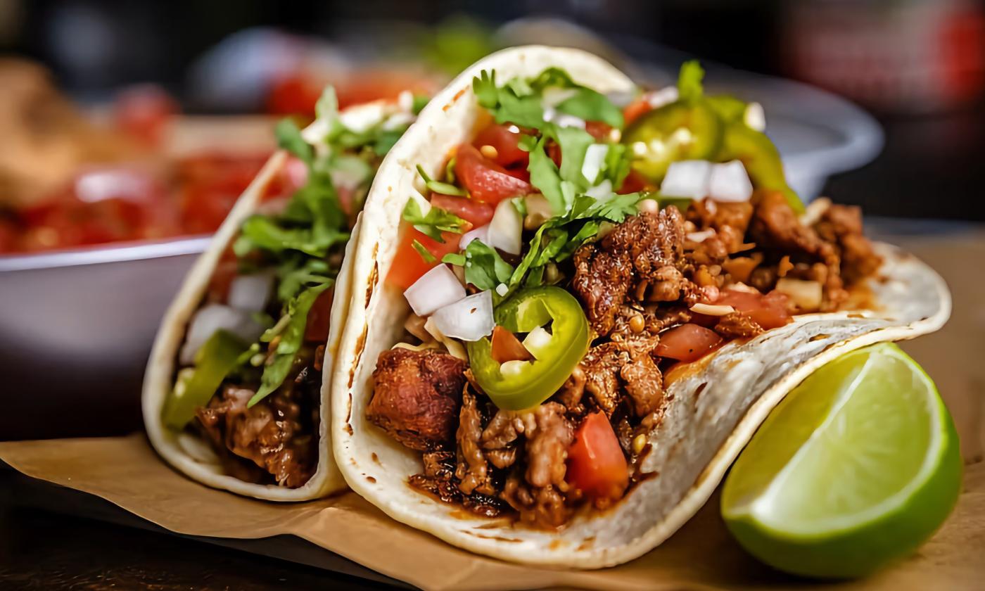 Tacos placed on a board with various toppings