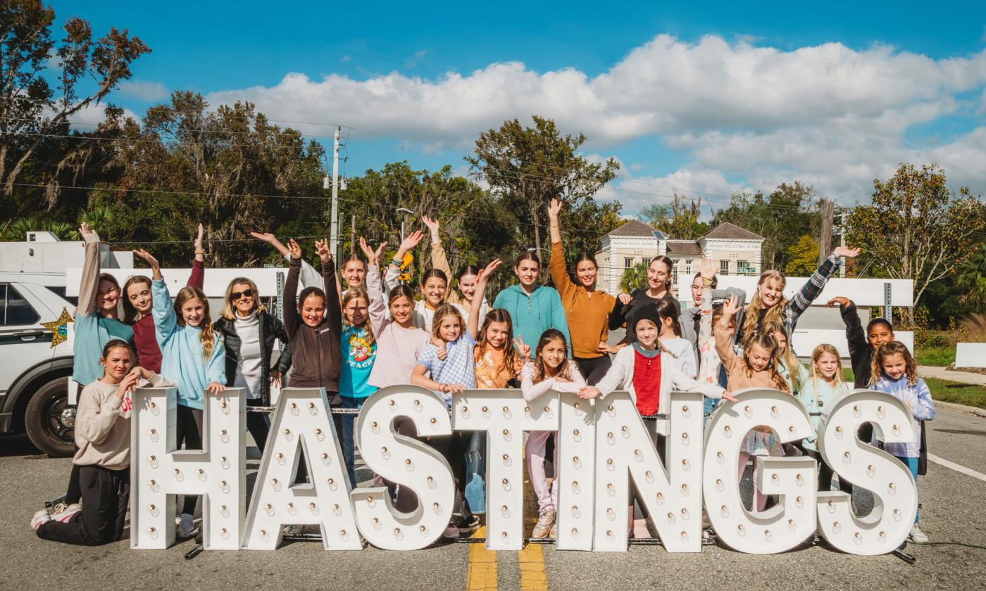 Dancers behind Hastings sign