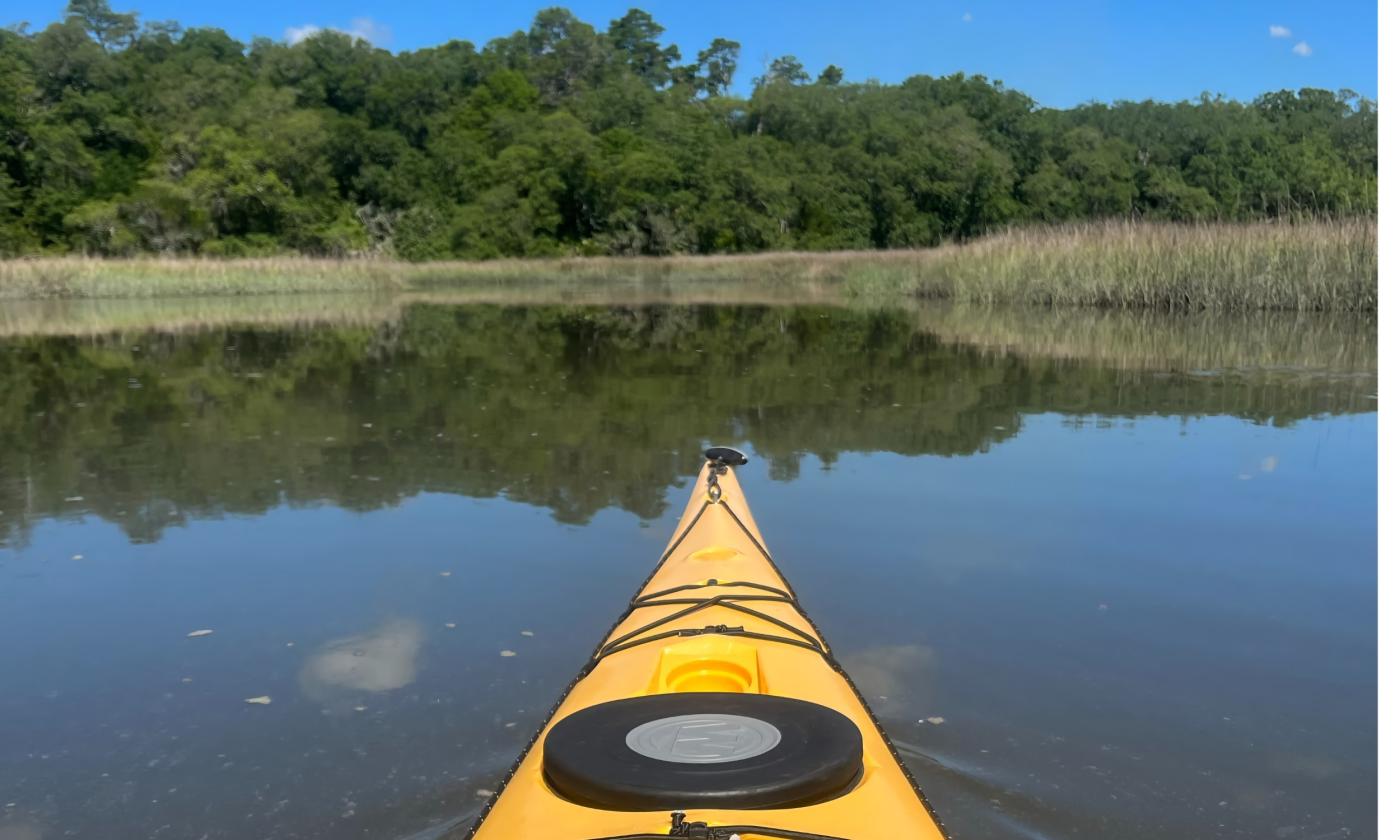 The prow of a yellow kayak in a placid river near St. Augustine