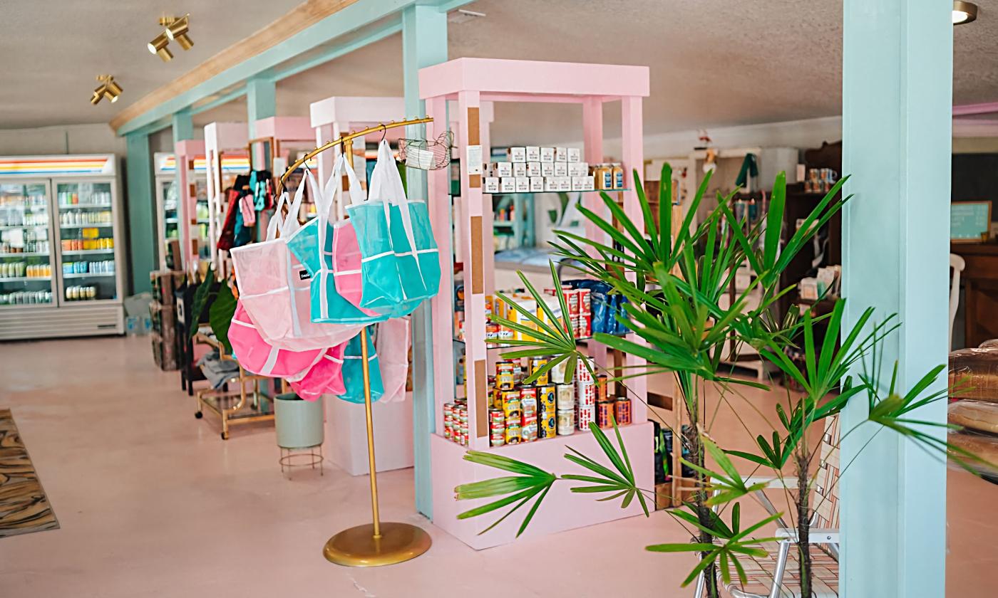A shop with food and tourist goods and a pink and aqua decor