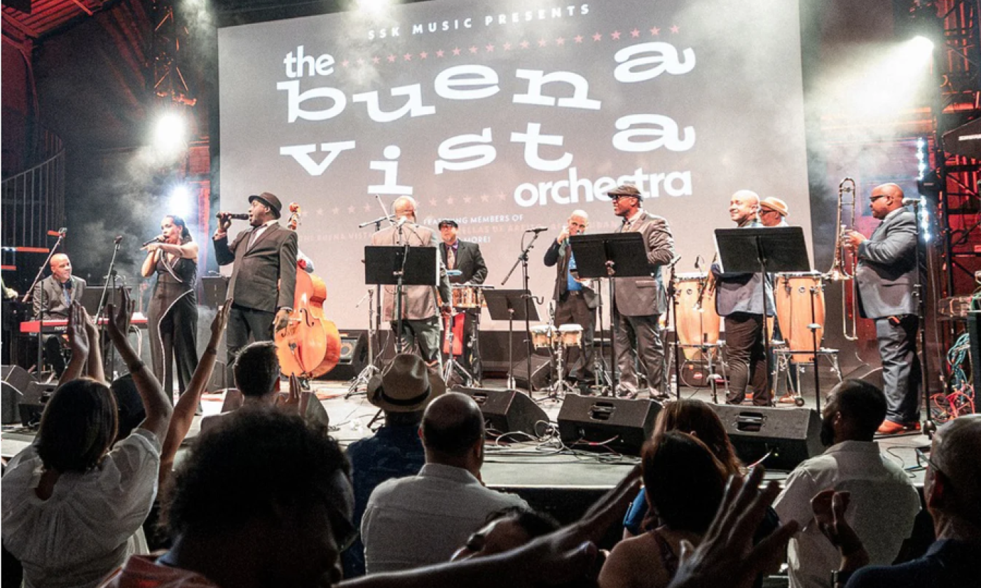 Bandmates from Buena Vista Orchestra perform on stage.