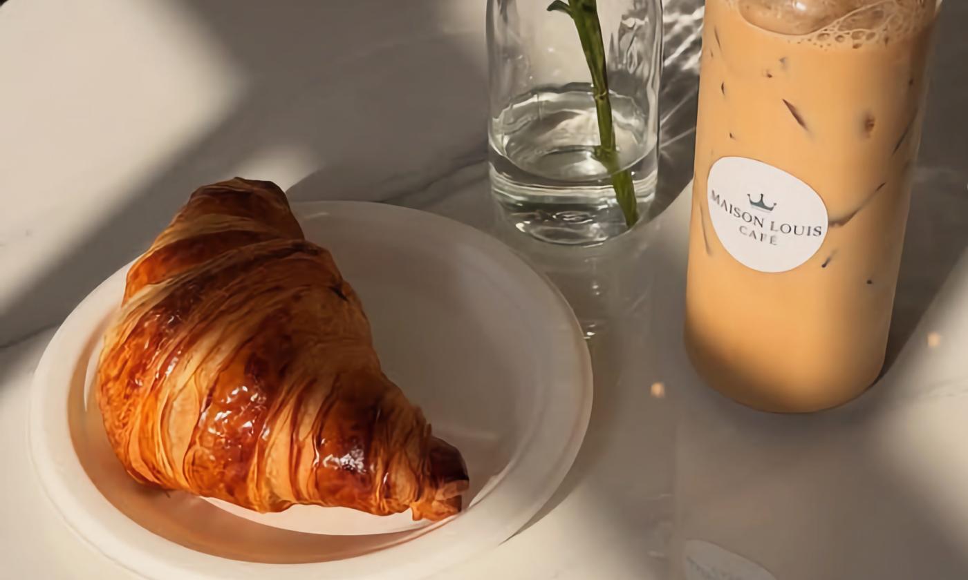 A croissant and iced coffee bottle