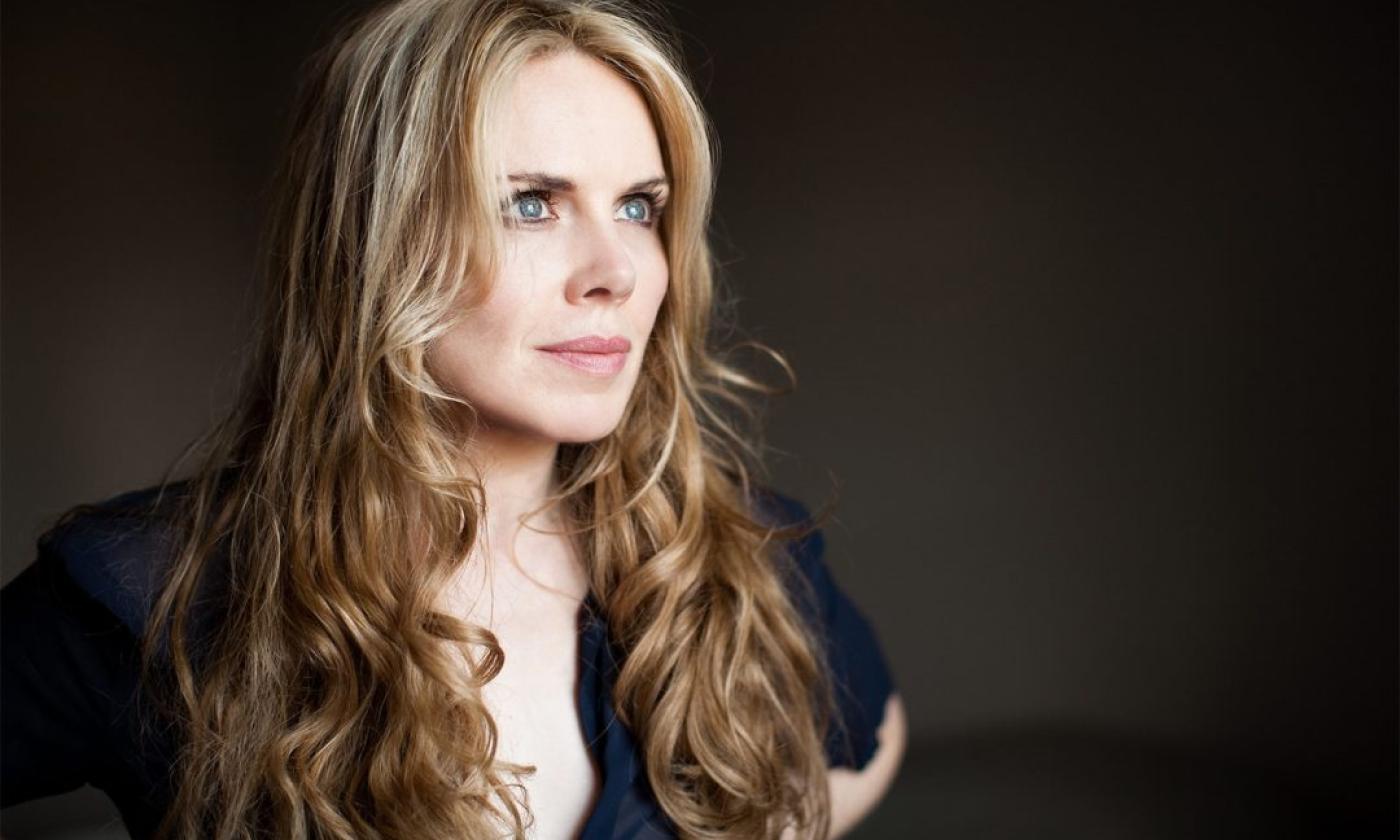 Mary Fahl poses against a black backdrop in a profile shot.